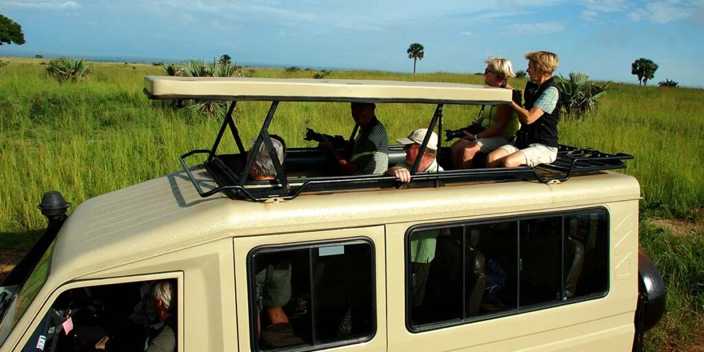 Family with children viewing wildlife from a safari vehicle in Murchison Falls