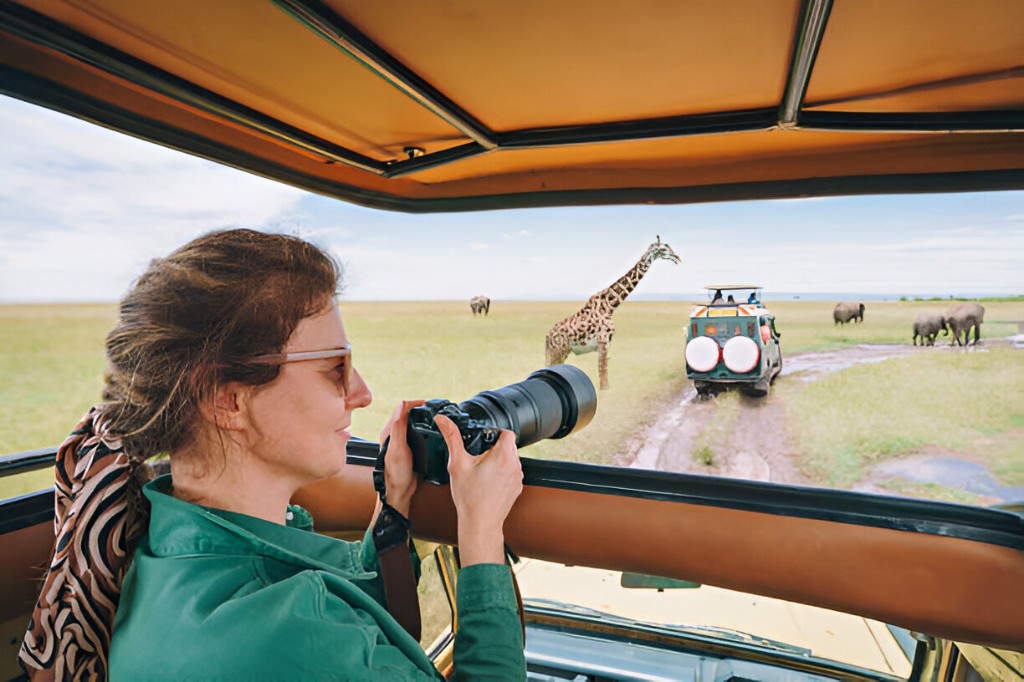 First-time safari guests smiling beside a 4x4 in Murchison Falls National Park
