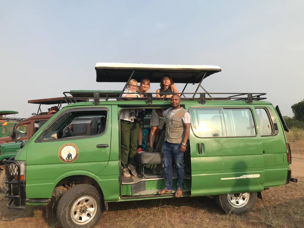 Professional Uganda safari guide scanning for wildlife with binoculars in Murchison Falls
