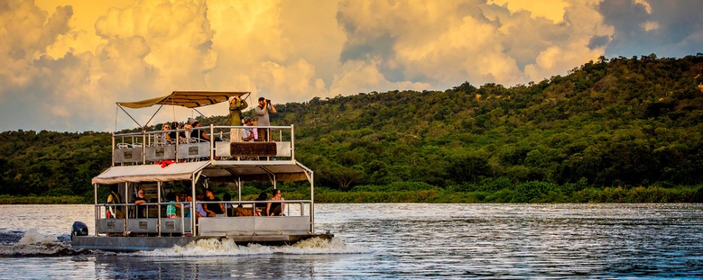 Wildlife photographer with long lens photographing birds on the Nile at Murchison Falls
